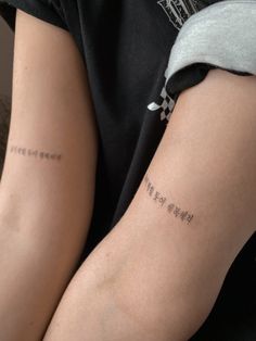 two people with tattoos on their arms and one has the word love written in chinese