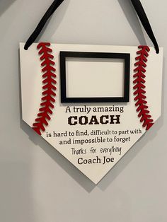 a baseball hanging on the wall with a coach's quote written in red and black