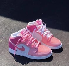 a pair of pink and white sneakers on the ground