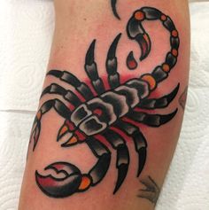 a black and orange scorpion tattoo on the leg