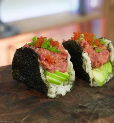 two pieces of sushi on a wooden board