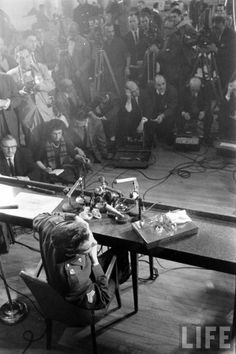 a group of people sitting around a table with microphones