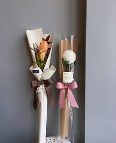 two vases with flowers in them sitting on a table