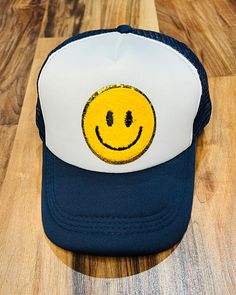 Adorable retro smiley face trucker hat with chenille patch! Snapback closure ensures a great fit. Casual Smiley Face Snapback Baseball Cap, Trendy Smiley Face Baseball Cap With Curved Brim, Casual Smiley Face Snapback Hat, Trendy Smiley Face Cap, Trendy Smiley Face Baseball Cap, Casual Trucker Hat With Smiley Face, Adjustable Smiley Face Fun Baseball Cap, Casual Smiley Face Trucker Hat Snapback, Fun Smiley Face Snapback Baseball Cap