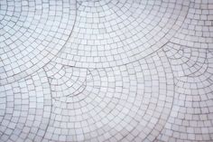 a close up view of a white tile pattern with drops of water on it's surface