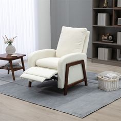 a white recliner chair sitting on top of a rug in front of a book shelf