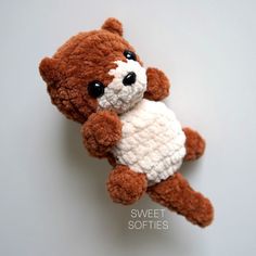 a brown and white teddy bear with black eyes sitting on top of a gray surface