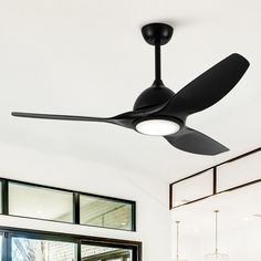 a black ceiling fan in a white room