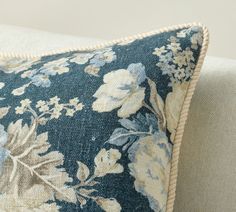 a blue and white floral pillow sitting on top of a couch