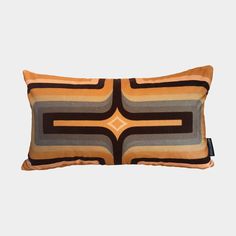 an orange and black pillow with geometric design on it's side, against a white background