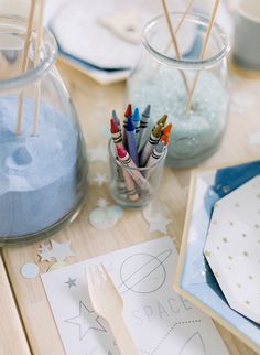 the table is set up with markers, pens and napkins for children to draw