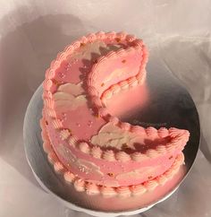 a heart shaped cake sitting on top of a metal plate next to a white sheet