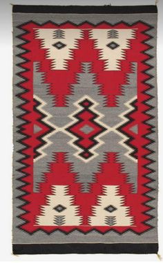 an old navajo rug with red, white and black designs on the front end is shown