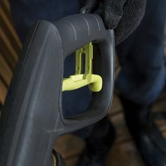 a person is holding a yellow handle on a black piece of luggage in their hands