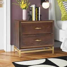 This nightstand showcases metallic accents that complement the chic finish to create a mid-century modern addition to your bedroom. It's made from engineered wood and features a brass-finished metal base with four legs and a wraparound support bar. A metal inlay behind the drawers matches the legs and adds to the retro aesthetic. The two drawers have bar pulls, and offer plenty of out-of-sight storage for your nighttime essentials. It measures 21.5" tall, so it'll fit next to low-profile bed fra Safavieh Furniture, Low Profile Bed, Walnut Nightstand, Bedside Storage, 2 Drawer Nightstand, Wood Nightstand, Drawer Nightstand, Wall Mounted Mirror, Night Stand