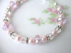 This children's adjustable pink cystal and pearl sparkle bracelet is perfect for a baptism, first Holy Communion or any special occasion.This sweet bracelet is made from pink sparkly Swarovski crystals, pink pearls and Bali sterling silver decorative spacers. The bracelet has a silver lobster claw clasp.Choose from these sizes below. All sizes have a 1/2" silver extender chain.To insure proper fit, please measure the child's wrist with a soft tape measure and add one inch.  NEWBORN 4.25"3 - 6 MO Adjustable Pink Crystal Bracelet For Wedding, Adjustable Pink Pearl Bracelet For Weddings, Pink Hypoallergenic Bracelets For Wedding, Pink Adjustable Pearl Bracelet For Mother's Day, Adjustable Pink Bracelets For Anniversary, Adjustable Pink Pearl Bracelet For Mother's Day, Adjustable Pink Rosary Bracelet For Mother's Day, Elegant Pink Bracelets For First Communion, Adjustable Pink Birthstone Bracelets