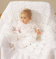 a baby is laying in a crocheted blanket