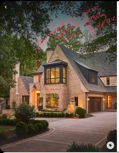 a large brick house with lots of windows and lights on it's front door