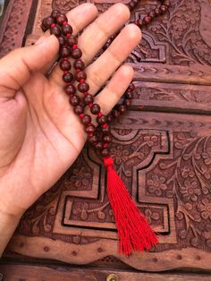 The beads of this mala are 100 % authentic and original. Tibetan / Mahayana style mala. Can be worn as a necklace or a wrap bracelet. Mala is made in traditional way with knots between the beads. Total beads 108+1 There are two kinds of sandalwood Red ( Rakta ) and white (Shweta). Rosaries of red sandalwood are useful for propitiating the goddess whereas white are useful for the gods. Red sandalwood is the symbol of Brahma and blessed by Lakshmi. It enlightens the super consciousness, provides i Holistic Mala With 8mm Beads For Festivals, Traditional Gemstone Beads Mala For Festival, Traditional Festival Mala With Gemstone Beads, Traditional Mala With 108 Beads For Festival, Red Handmade Mala For Healing, Red Beaded Mala For Meditation, Red Mala For Meditation, Red Hand-strung Mala For Healing, Red 8mm Beads Spiritual Mala