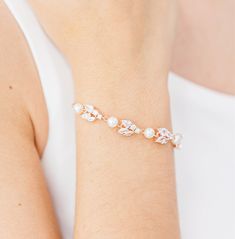 a woman wearing a bracelet with pearls on it