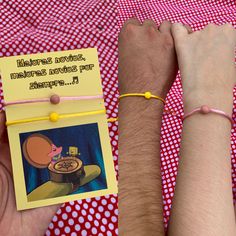 two people are holding hands over a red and white checkered table cloth with a yellow note attached to it