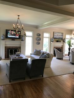 a living room filled with furniture and a flat screen tv mounted on the wall above a fireplace