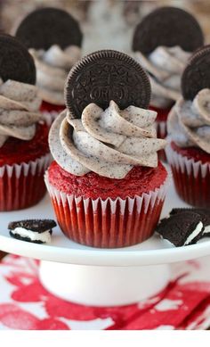 cupcakes decorated with oreo cookies and cream frosting on a white plate