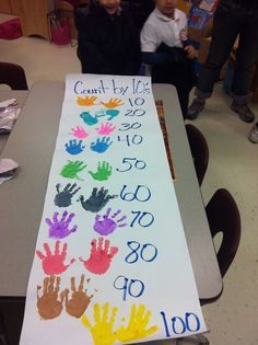 two children are standing in front of a sign with handprints on it