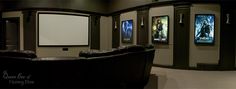 a home theater with leather seats and movie posters on the walls, along with a projector screen