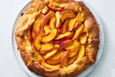 a pie with sliced peaches is on a plate