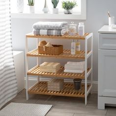 a bathroom with white walls and wooden shelves