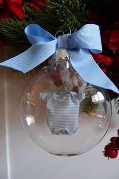 a baby's first christmas ornament with a blue ribbon hanging from it