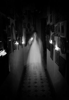 a person walking down a hallway in the dark