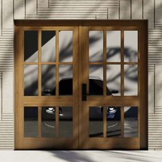 a car is seen through the windows of a wooden door