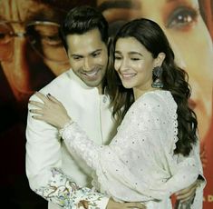 a man and woman hugging each other in front of a movie poster