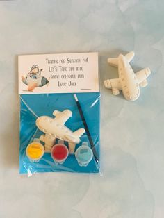 there is a toy airplane and some paint on the table with it's packaging