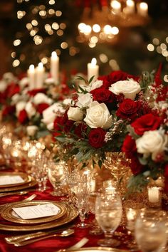 red and white flowers are in vases on a table with gold place settings for dinner