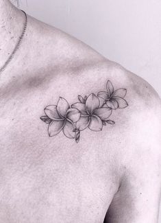 a black and white photo of a woman's chest with flowers on it