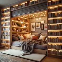 a bed with lots of books on it in a room filled with shelves and lights