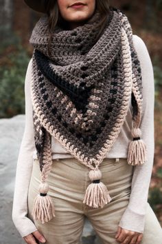 a woman wearing a hat and scarf with tassels