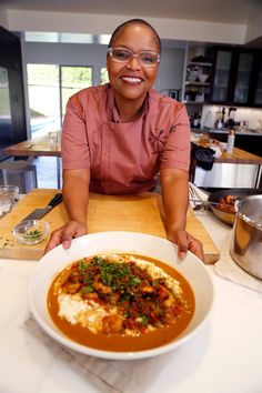 a woman sitting at a table in front of a bowl of food