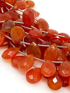 a bunch of orange beads on a white surface