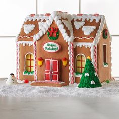 a gingerbread house decorated with icing and candy canes for the holiday season