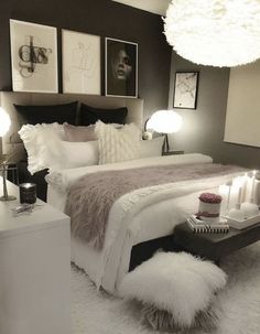 a white bed sitting next to two lamps and pictures on the wall