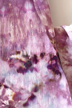 the fabric is covered in purple and pink dyes, with small flowers on it