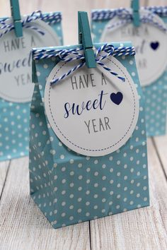 three small bags with blue and white polka dots on them, one has a tag that says have a sweet year