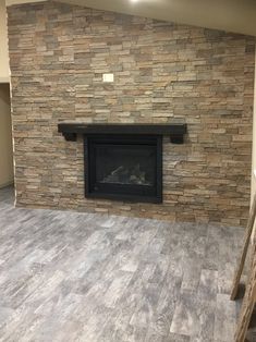 an empty living room with a fireplace and stairs in front of the fire place that is built into the wall