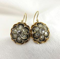 Circa 1840's. A beautiful pair of antique earrings... A domed floral motif in 18 karat gold with 1.04 carat of rose cut diamonds bezel set and framed in black enamel. These earrings are accompanied by an independent written appraisal Appraisal Value: $4,050.00 These handmade antique earrings measure 15.6mm in diameter and 6.40mm thick. They are for pierced ears with a Shepherd's hook. Metal: Tested 18 karat Stone information: (14) Rose Cut Diamonds Measurements: 2.70mm-4.00mm x 1.80mm Weight: 14 Antique Jewelry With Rose Cut Diamonds, Antique Drop Earrings With Rose Cut Diamonds, Antique Rose Cut Diamond Drop Earrings, Antique Rose Cut Diamond Earrings, Ornate Collectible Rose Cut Diamond Jewelry, Shepherds Hook, Antique Earrings, Bezel Diamond, Rose Cut Diamond