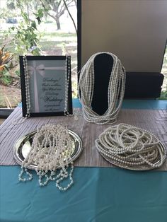 some pearls are sitting on a table next to a plaque and other items that have been placed around it