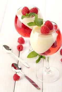 two desserts with raspberries in them on a table